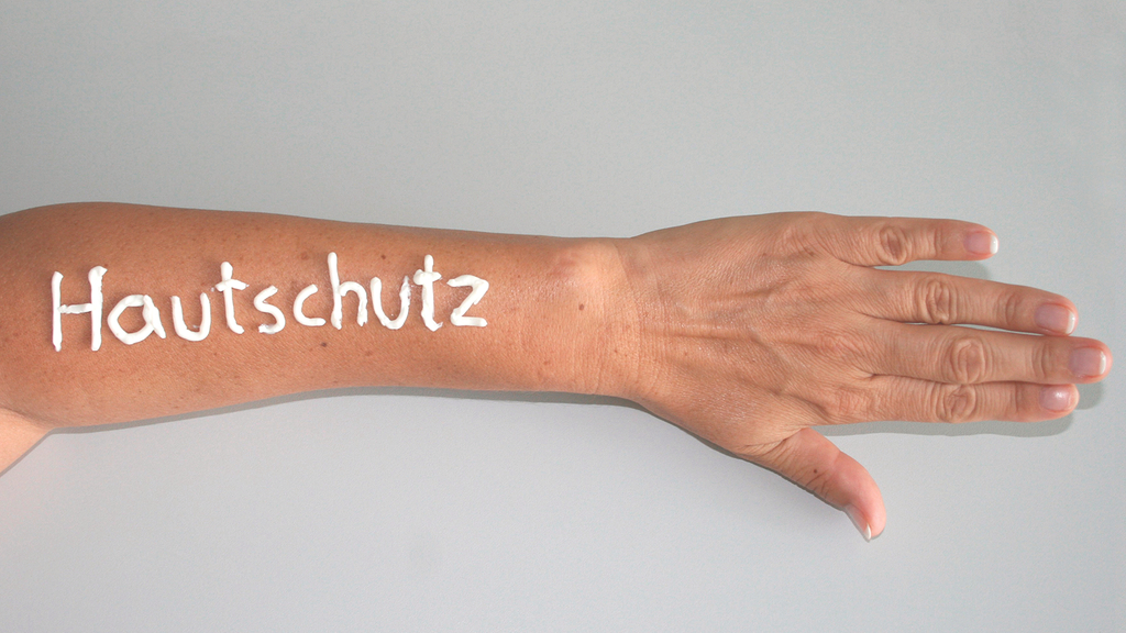 Vergrößerung des Bildes für Auf einem Unterarm ist mit Hautcreme das Wort Hautschutz aufgeschrieben.