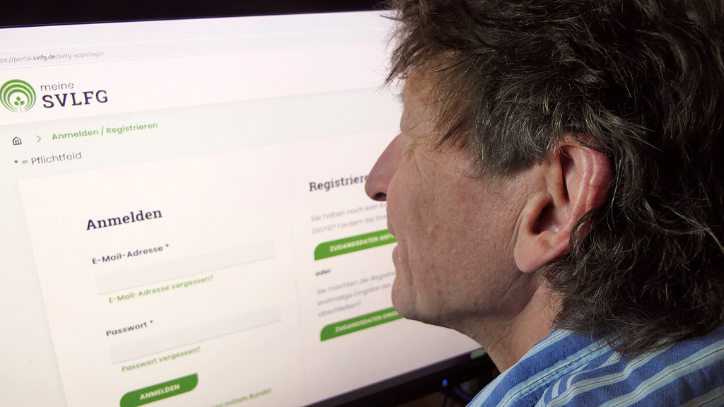 Vergrößerung des Bildes für Ein Mann sitzt vor einem Bildschirm, der die Startseite des Versichertenportals "Meine SVLFG" anzeigt..