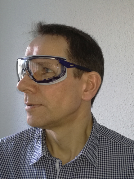Vergrößerung des Bildes für Mann mit Gestellbrille schaut zur Seite.