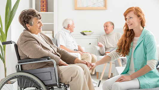 Seniorin im Pflegeheim mit Pflegekraft