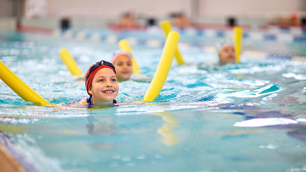 Vergrößerung des Bildes für Mädchen mit Schwimmnudel im Schwimmbad.