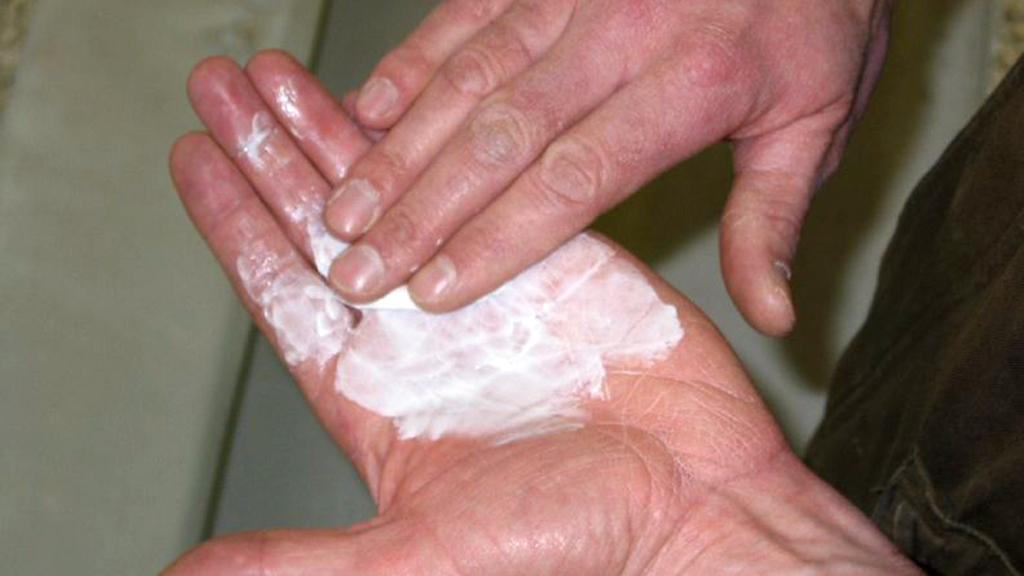 Vergrößerung des Bildes für Bild: Hände, die sich eincremen.