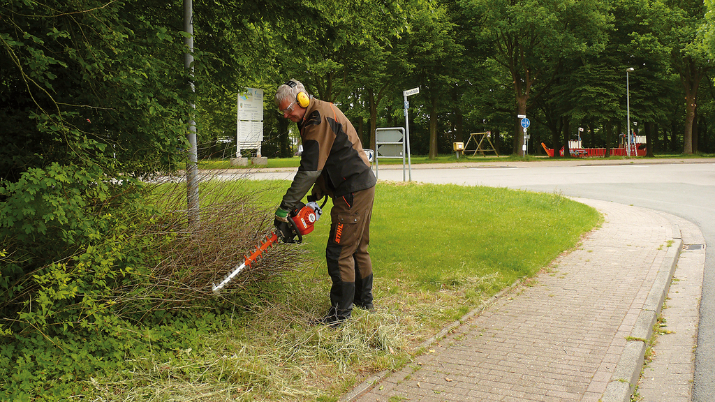 Vergrößerung des Bildes für Mann mit Gehörschutz beim Arbeiten mit dem Freischneider .