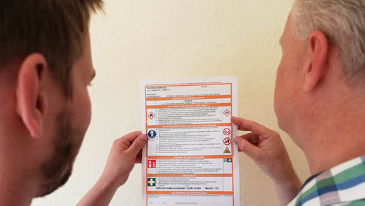 Zwei Männer schauen sich eine Betriebsanweisung an