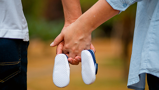 Mann und Frau mit Babyschuhen