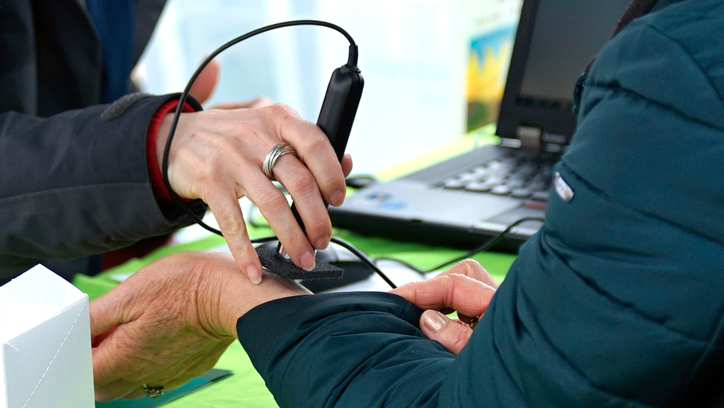 Vergrößerung des Bildes für Am Arm wird mit einem UV-Messgerät die persönliche Eigenschutzzeit der Haut unter Sonnenstrahlung gemessen.