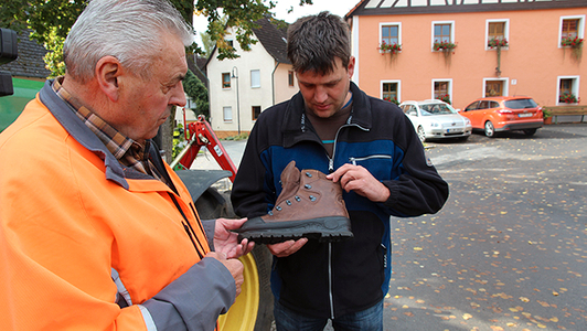 Zwei Männer schauen sich einen Sicherheitsschuh an