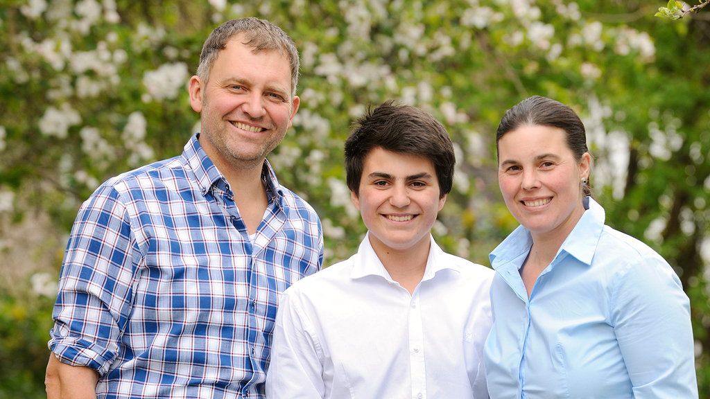 Vergrößerung des Bildes für Portrait der Familie Stenglein. Herr und Frau Stenglein stehen am Rand, der Sohn in der Mitte. Alle lachen.
