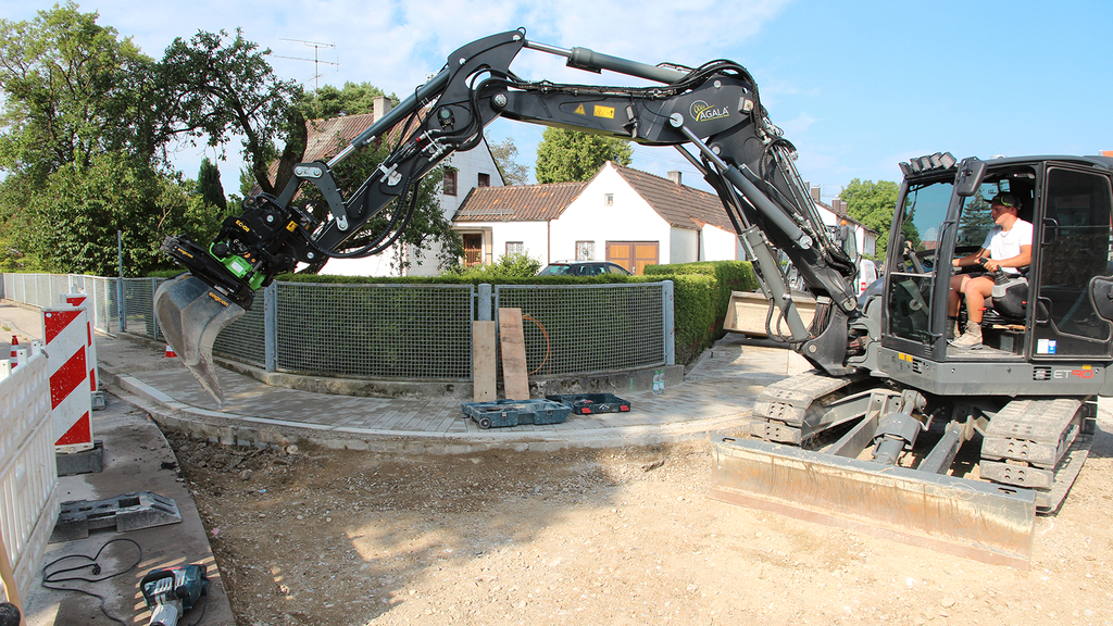 Vergrößerung des Bildes für Mann im Bagger führt Arbeiten an der Straße durch.
