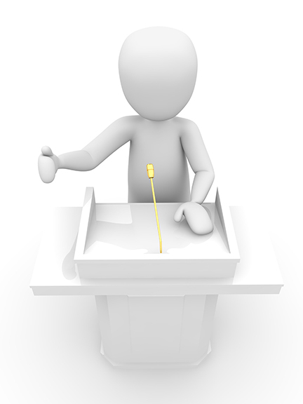 Vergrößerung des Bildes für Männchen am Rednerpult mit Mikrofon.