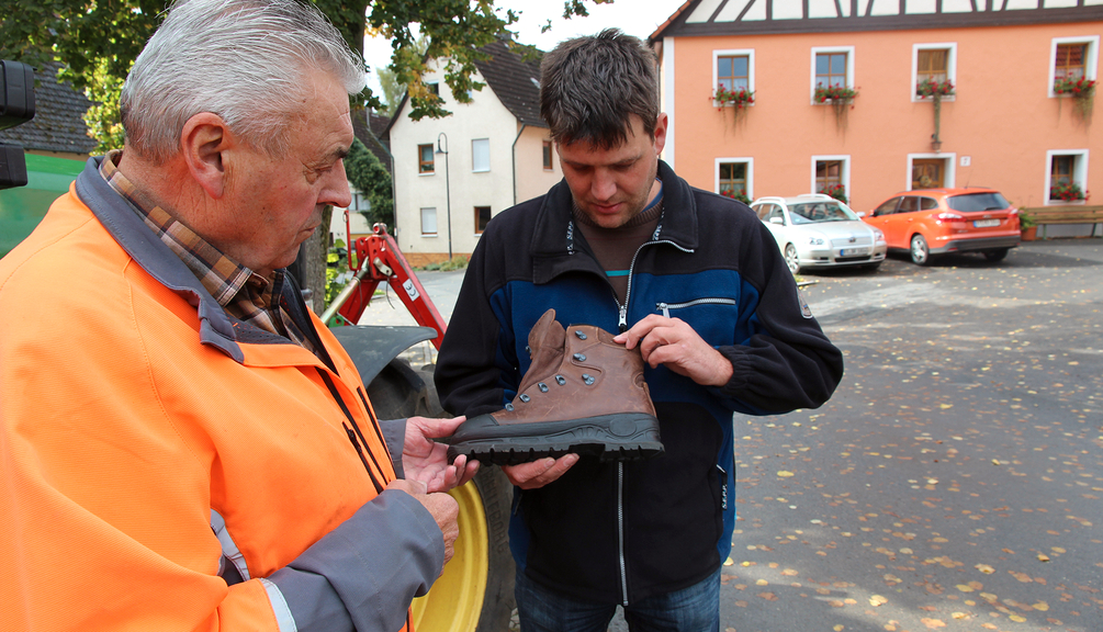 Zwei Männer schauen sich einen Sicherheitsschuh an