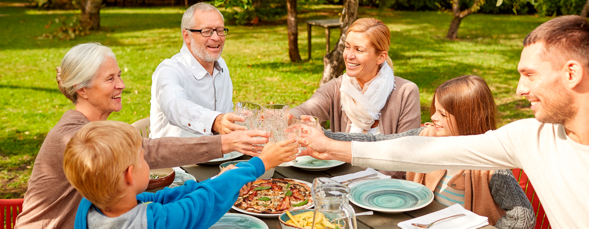 Großfamilie beim Essen im Bauerngarten