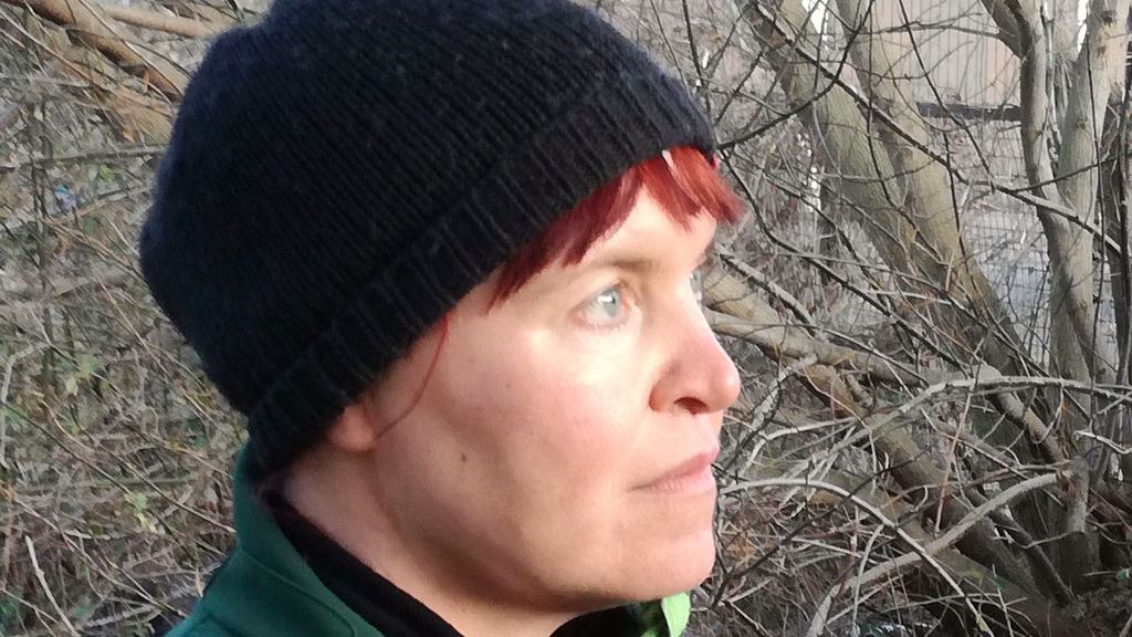 Vergrößerung des Bildes für Frau mit Mütze auf dem Kopf schaut zur Seite. .